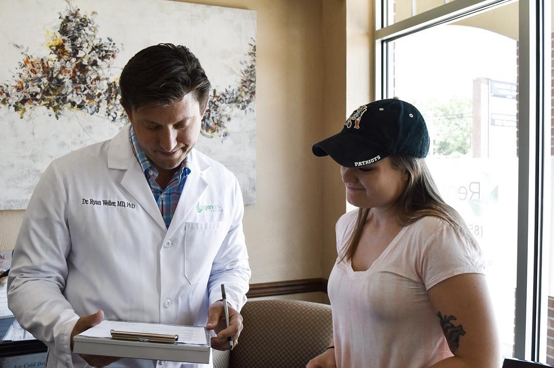 Dr. Ryan Welter reviewing consultation notes with a patient in a bright office setting